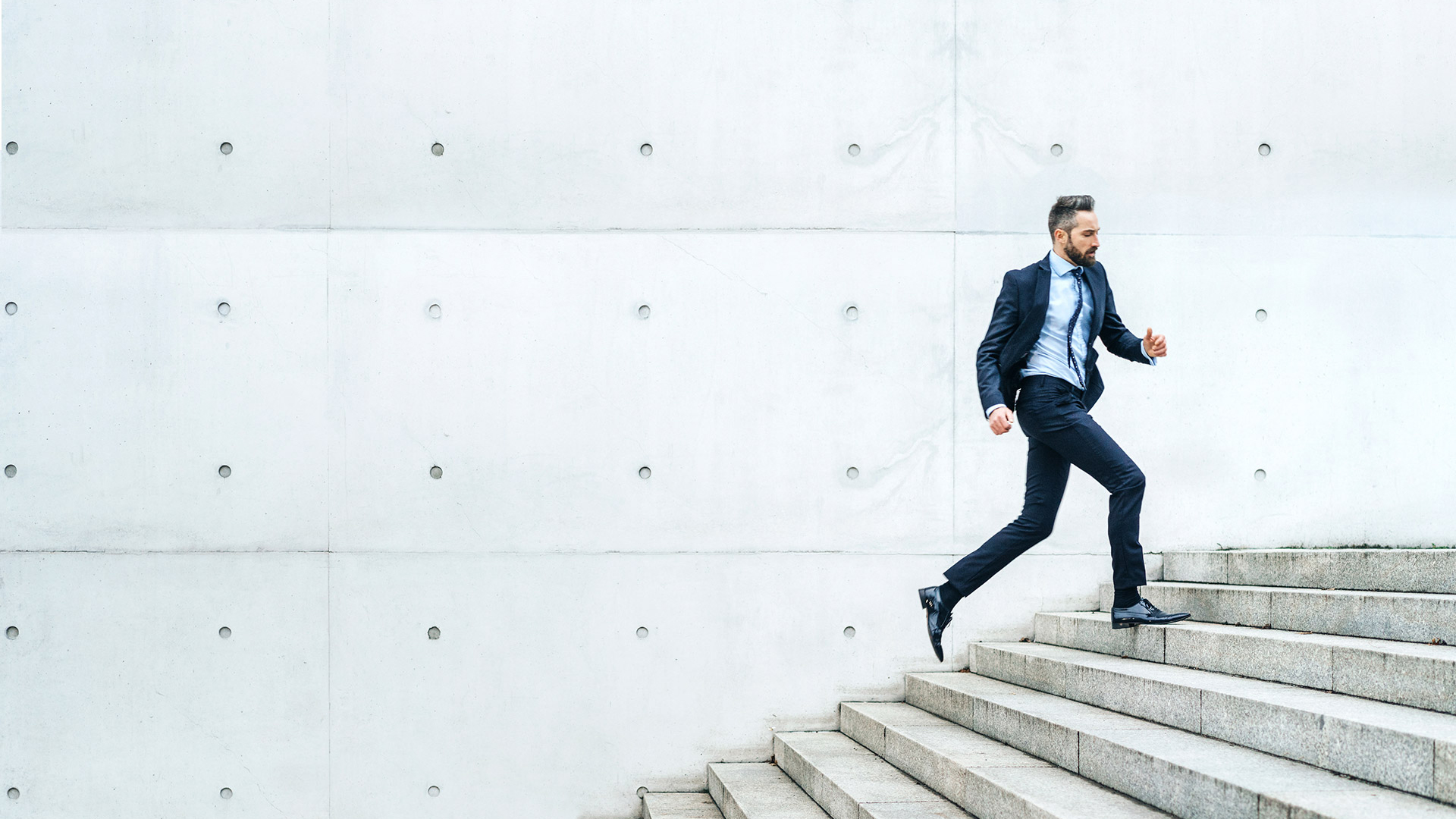 Man in suit running up stairs